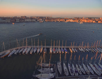 High angle view of buildings by sea against sky at sunset