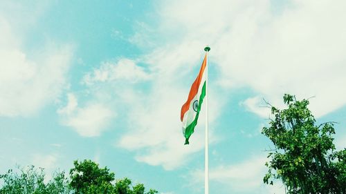 Low angle view of flag by trees