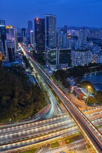 High angle view of illuminated street amidst buildings at night