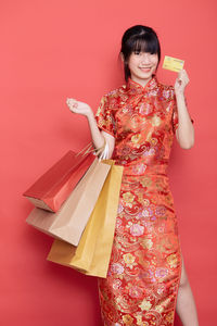 Woman standing against red background