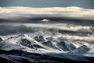 Scenic view of mountains against cloudy sky