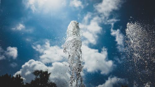 Close-up of fountain splashing water against cloudy sky