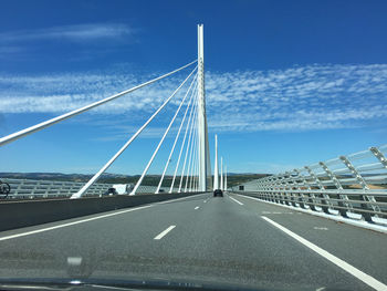 Low angle view of suspension bridge against sky