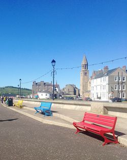 Cars on street against clear blue sky