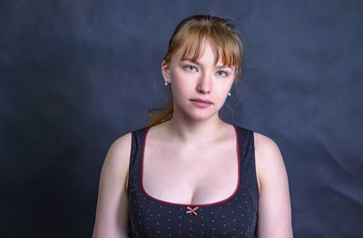 Portrait of a beautiful young woman against black background