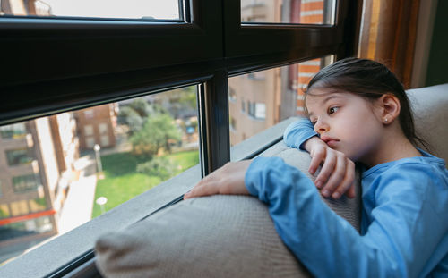 Portrait of boy looking through window