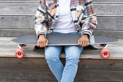 Low section of man sitting on skateboard