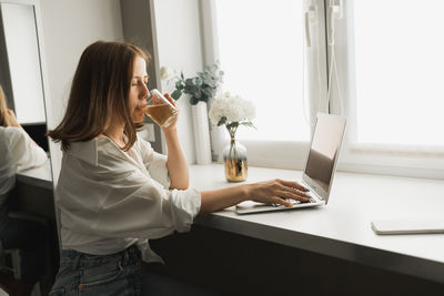 Side view of woman using digital tablet in office