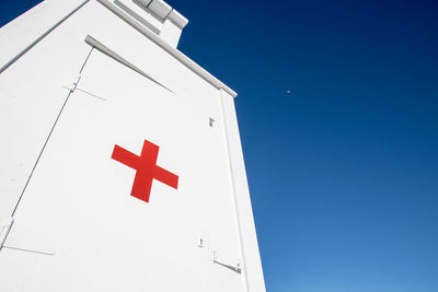 Low angle view of flag against clear blue sky