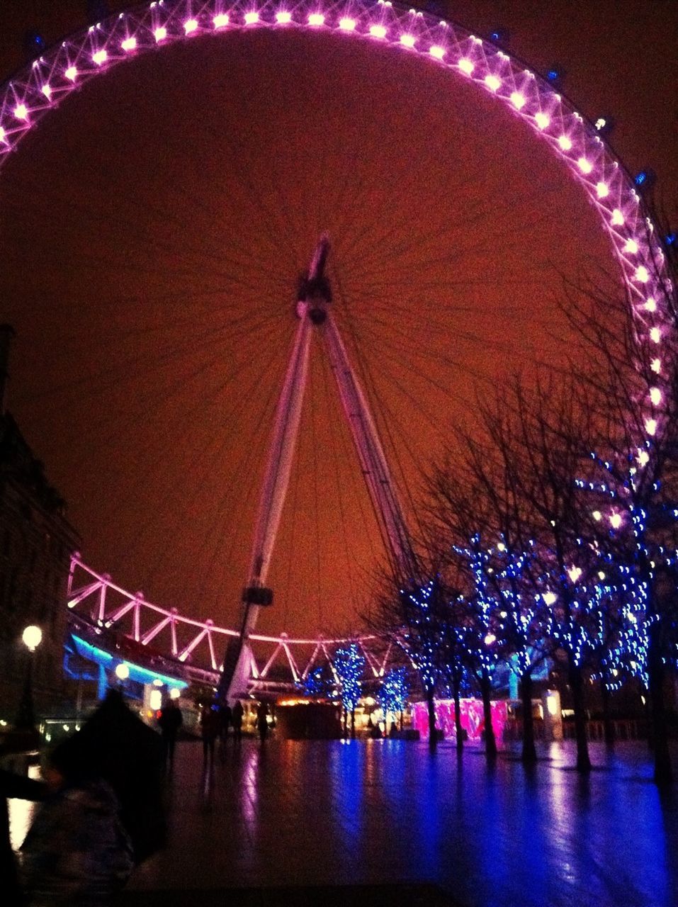 illuminated, night, arts culture and entertainment, ferris wheel, amusement park, amusement park ride, water, built structure, architecture, sky, long exposure, motion, reflection, river, multi colored, waterfront, celebration, low angle view, travel destinations, outdoors