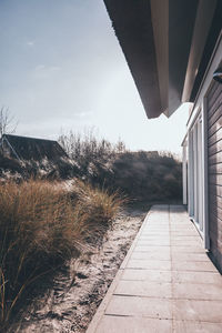 Footpath by sea against sky