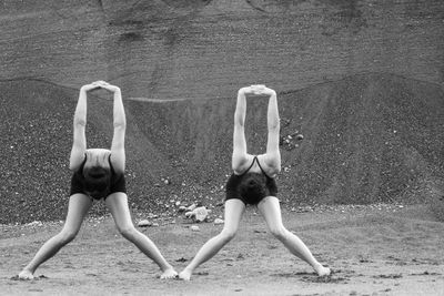 Female gymnasts stretching on field