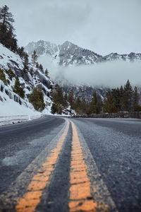 Road amidst snowcapped mountains against sky