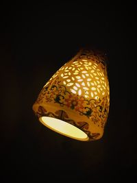 Close-up of illuminated lamp over black background