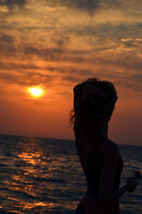 Silhouette woman at beach during sunset