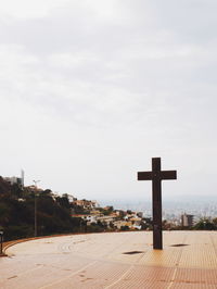 Cross on beach against sky
