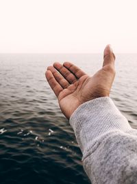 Midsection of man in sea against sky