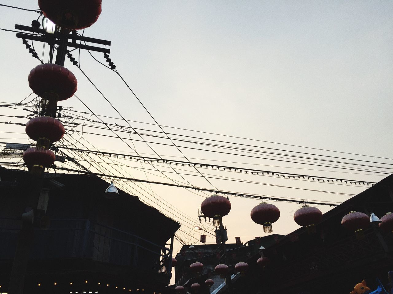 low angle view, sky, hanging, celebration, no people, built structure, outdoors, architecture, day, christmas ornament, chinese lantern festival