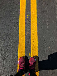 Low section of person standing on road