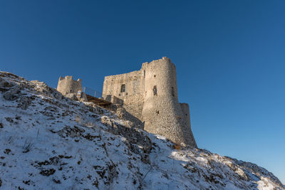 Low angle view of fort against clear blue sky