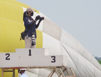 Low angle view of man on yellow wall against sky