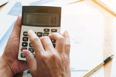 Close-up of hand holding calculator