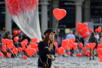 Portrait of woman with red balloons