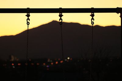 Mountain and city lights over a swing chain