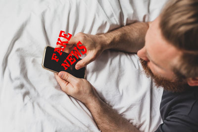 High angle view of man relaxing on bed