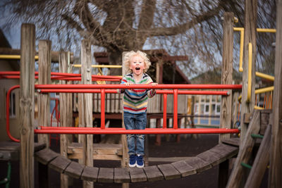 Young boy laughing and playing on playground at a park