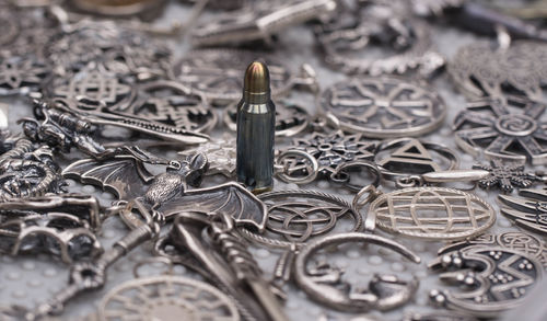 Close-up of bullet amidst pendants on table