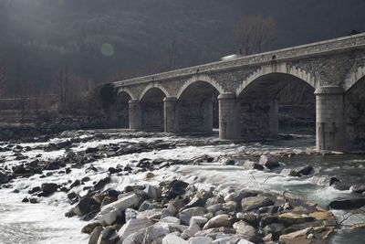 Arch bridge over river during winter