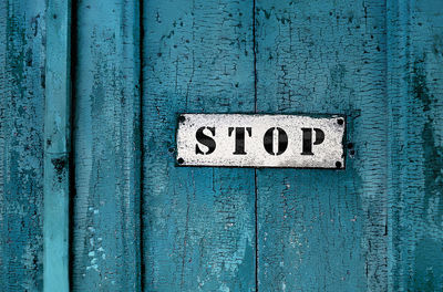 Close-up of a sign saying ''stop''on the grunge wooden background