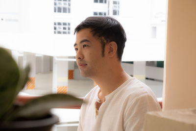 Portrait of young man sitting on table at home