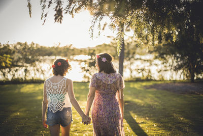 Rear view of friends standing against trees