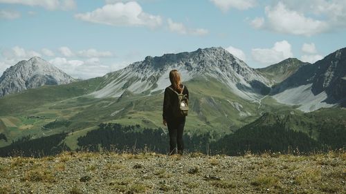 Rear view of woman standing on mountain landscape