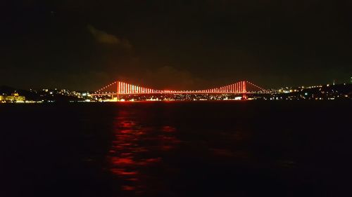 Suspension bridge over river at night