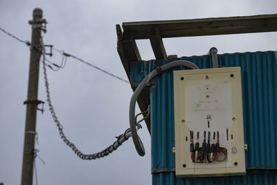 Low angle view of telephone pole against sky