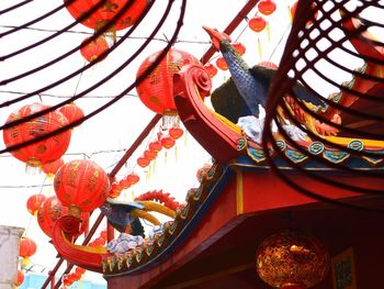 Low angle view of lanterns hanging by building against sky