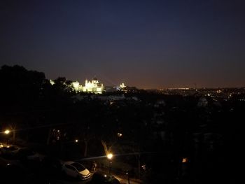 Illuminated cityscape against sky at night