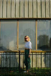 Portrait of woman standing against railing