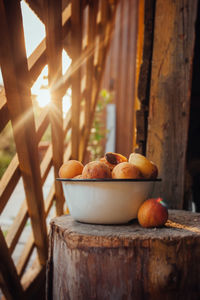 Ripe yellow homemade apricot with cracks and flaws in a deep metal plate on a wooden stump