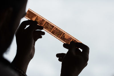 Close-up of man looking at negative film