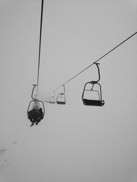 Low angle view of overhead cable car against sky