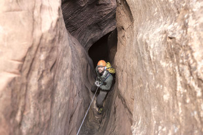 High angle portrait of hiker climbing rock