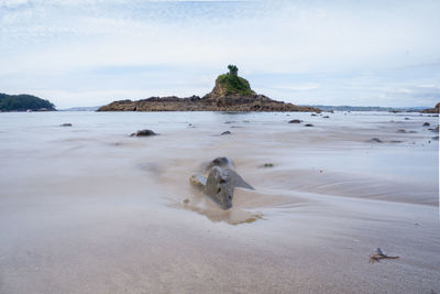 Scenic view of rocks on beach against sky