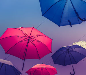 Low angle view of umbrellas against sky during sunset