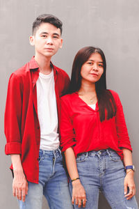 Portrait of smiling friends standing against wall