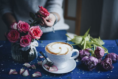 Coffee cup and roses on table