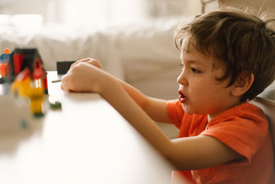 Cute boy is playing constructor at home. kid playing block toys in home at nursery.